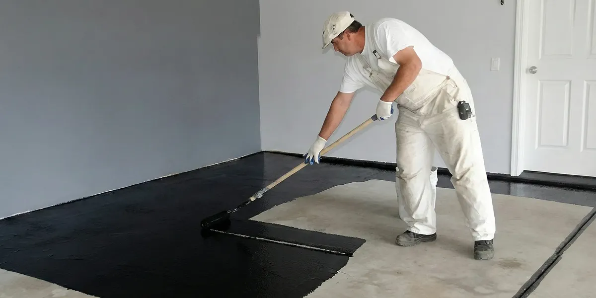 basement waterproofing professional applying waterproof coating to protect a basement floor in Wilmington, NC
